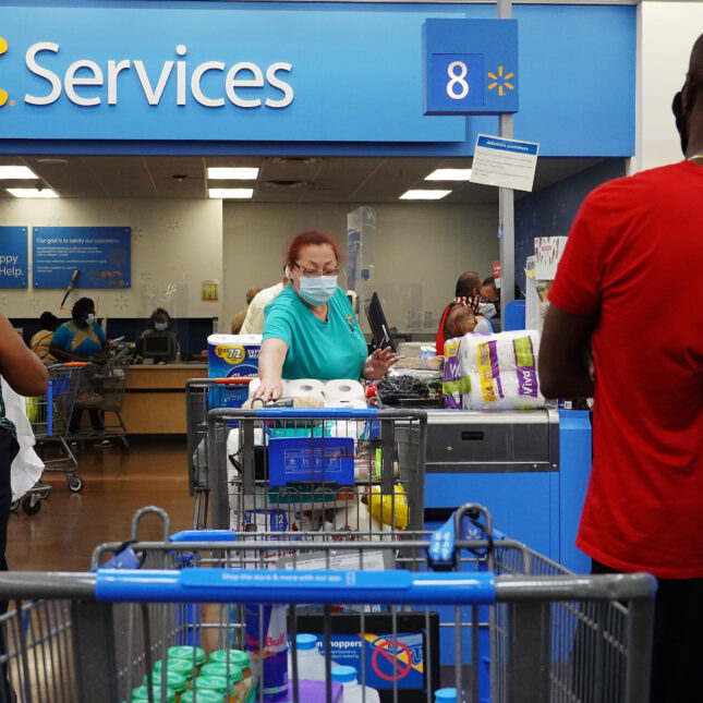 Photograph of customers inside of a Walmart store – business of healthcare coverage from STAT