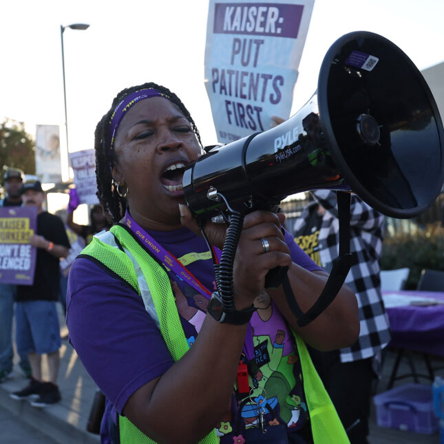 A striking Kaiser Permanente worker uses a bullhorn as she walks the picket line in front of the Kaiser Permanente Vallejo Medical Center on October 06, 2023 in Vallejo, California.